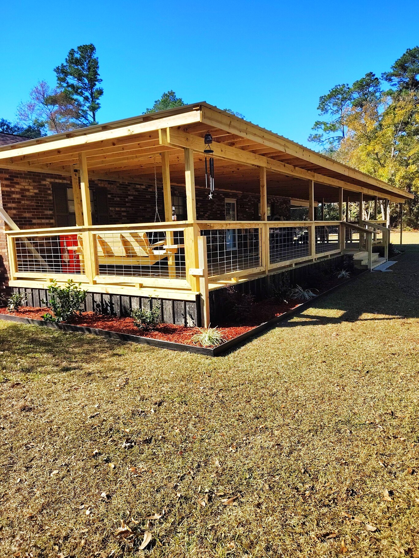 Custom porch landscaping with fresh mulch beds